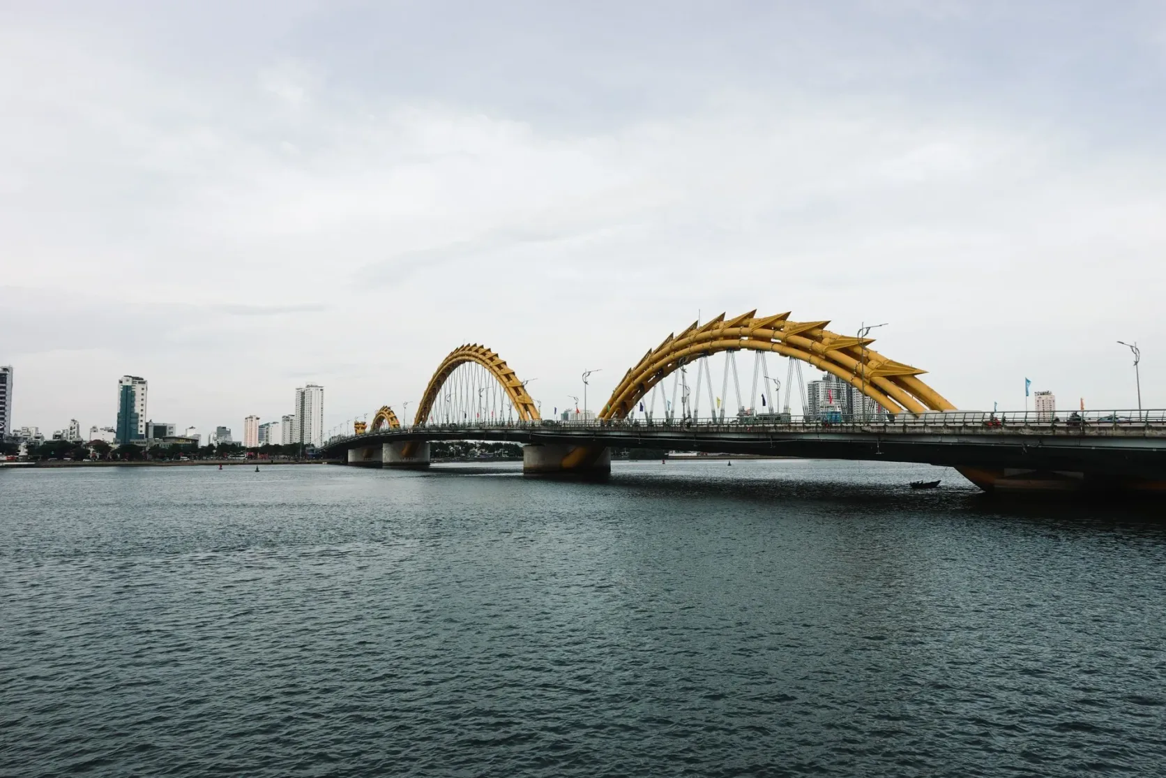 Les arches jaunes du pont du Dragon sur la rivière Hàn, en plein jour.