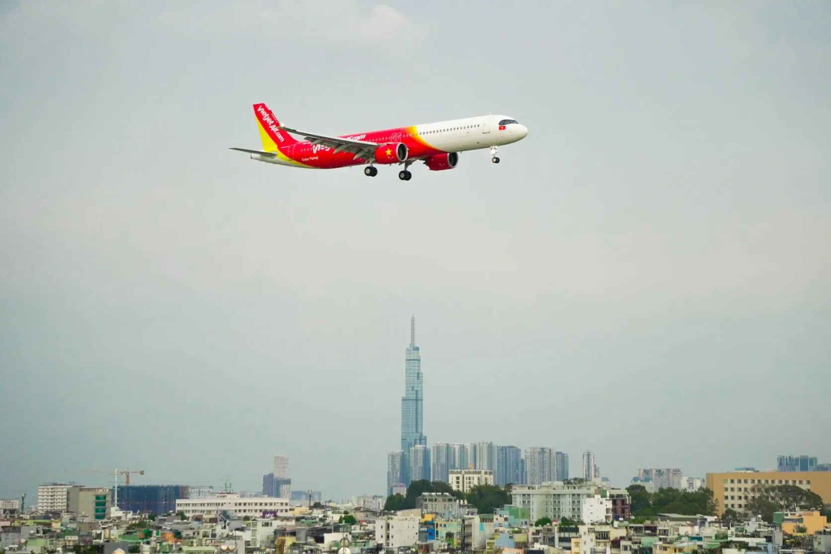 Ein Flugzeug im Landeanflug über Ho-Chi-Minh-Stadt; darunter der Turm Landmark 81.