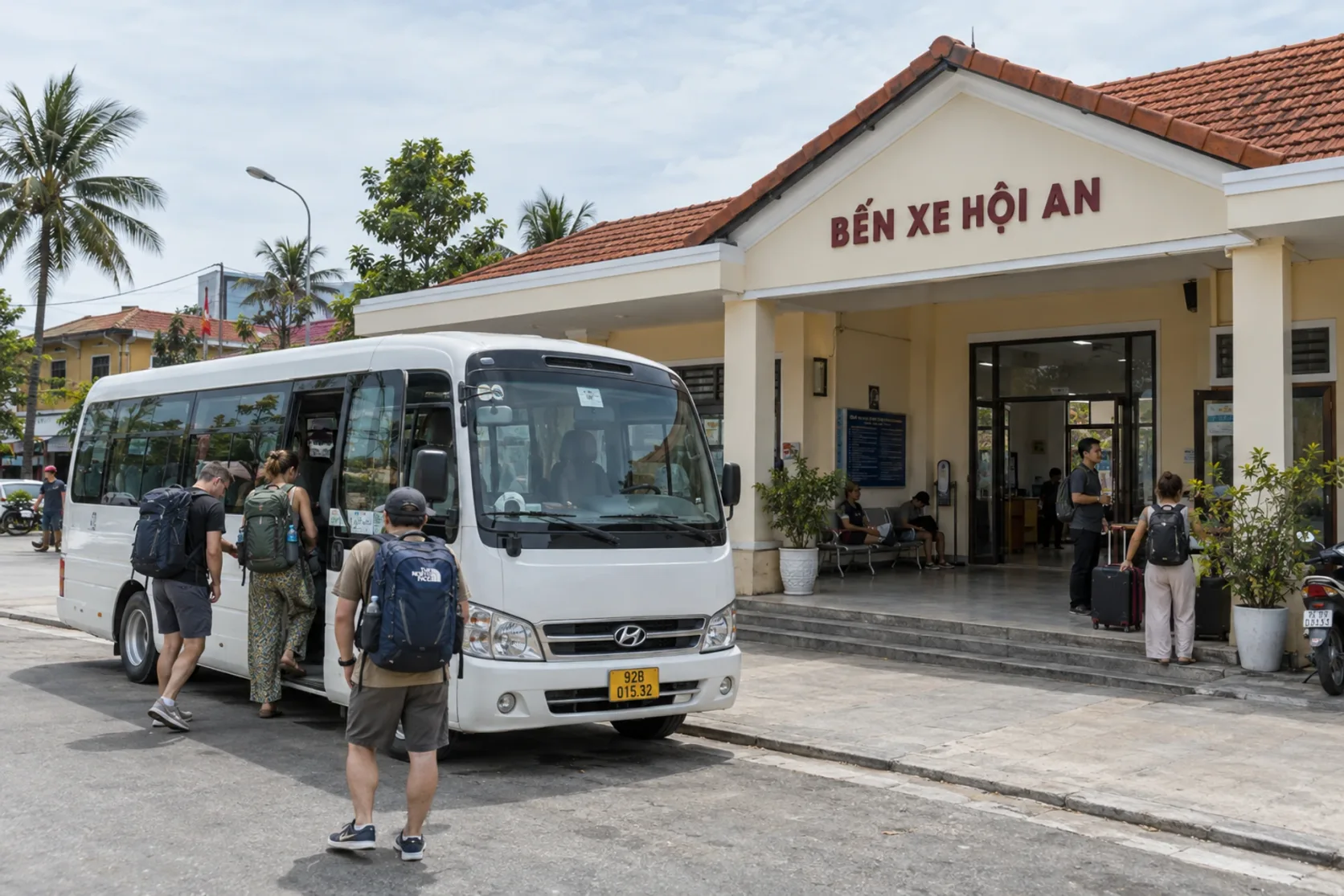 Un minibus embarque des passagers devant la gare routière de Hoi An.