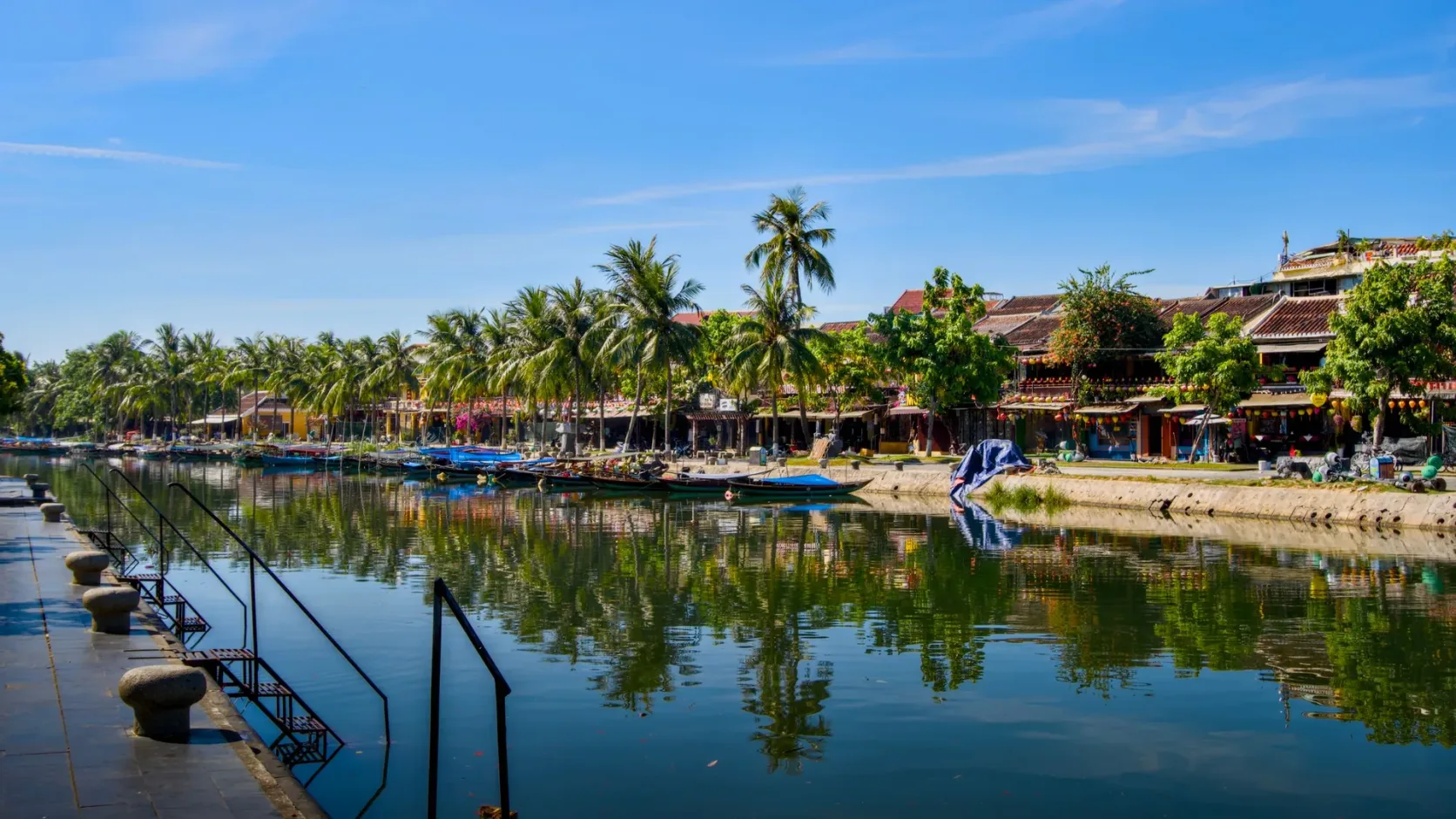 The Thu Bon river at Hoi An, palms reflected in the water.