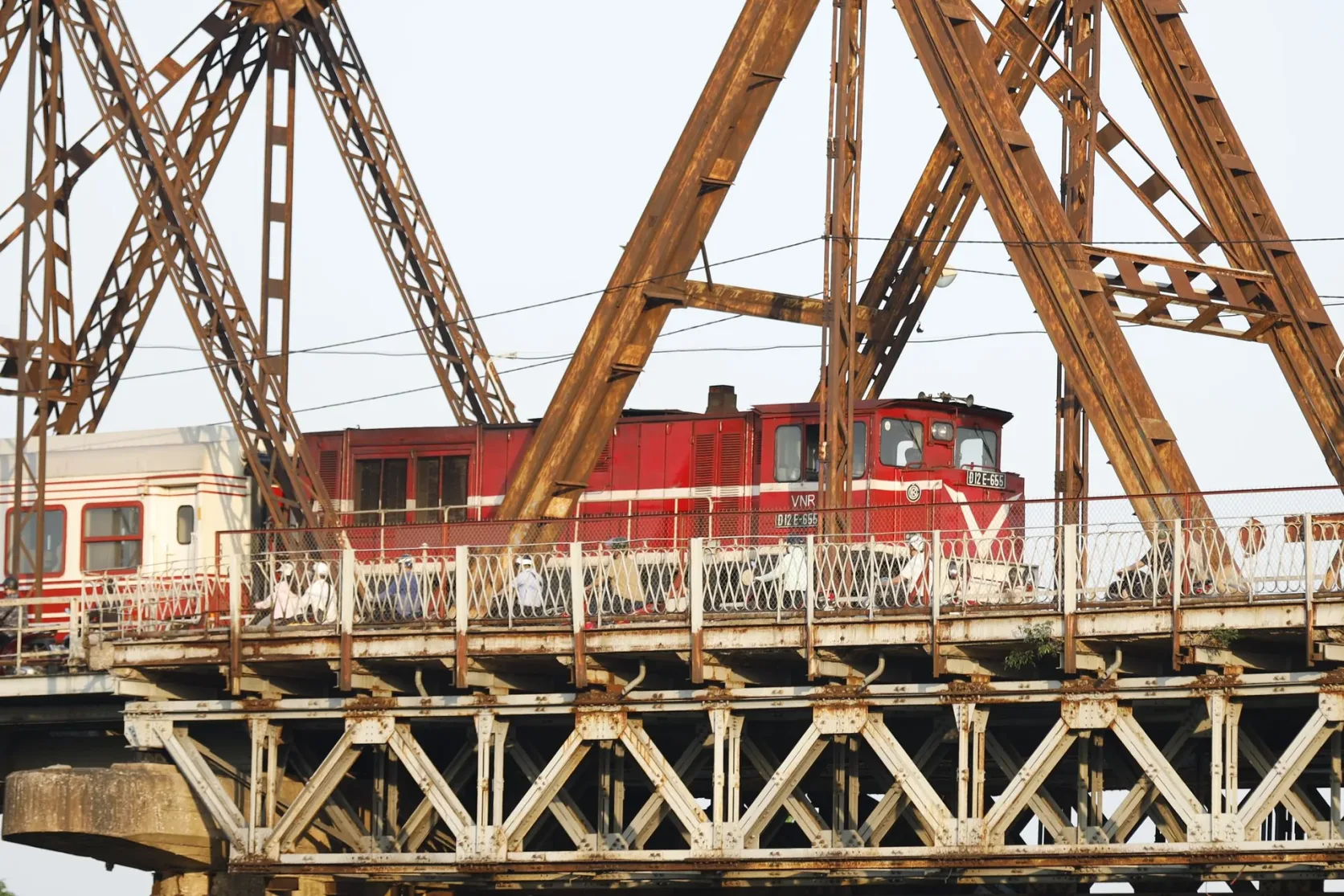 Eine rote Diesellok auf der Long-Biên-Brücke in Hanoi.