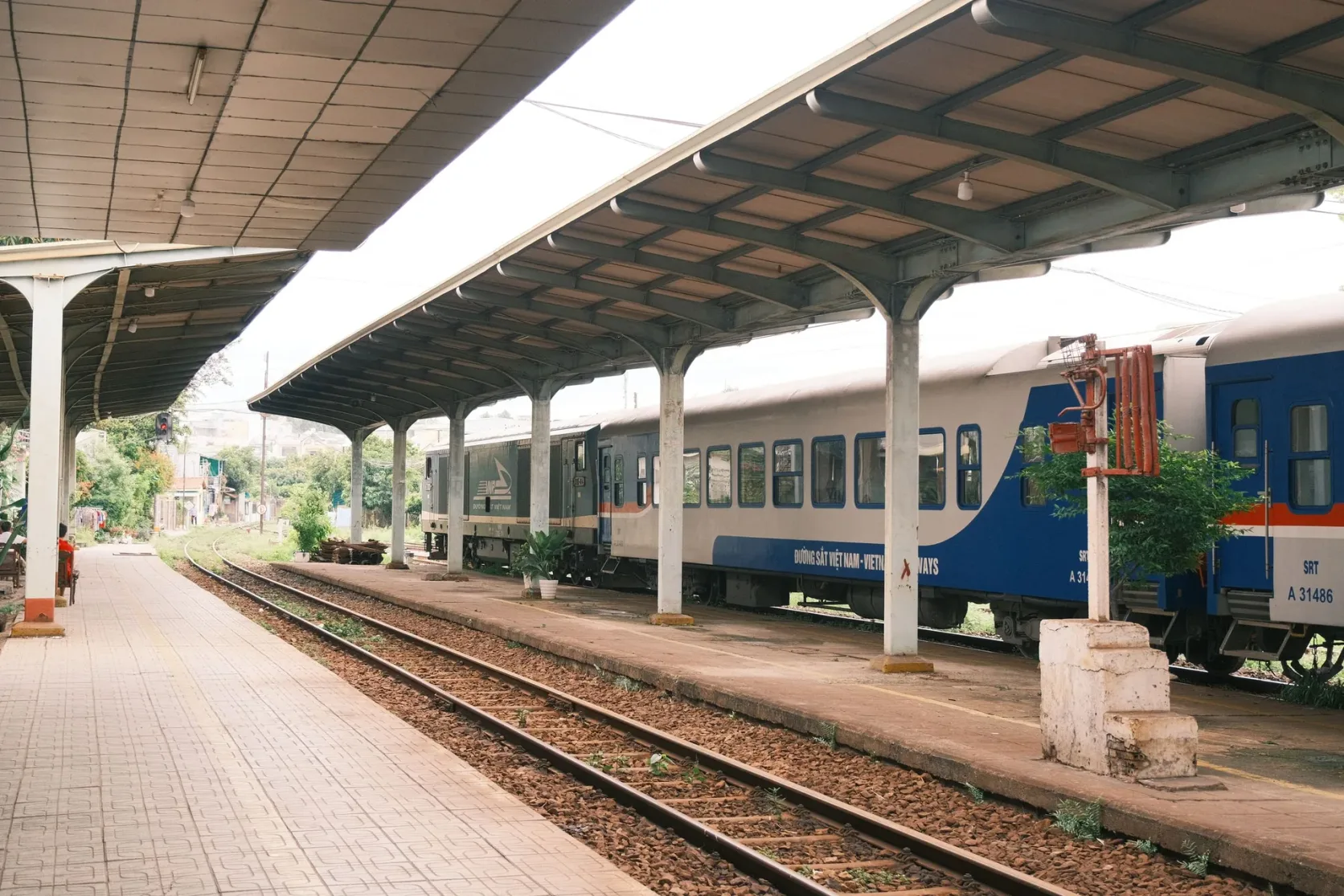 A covered platform beside blue passenger carriages.