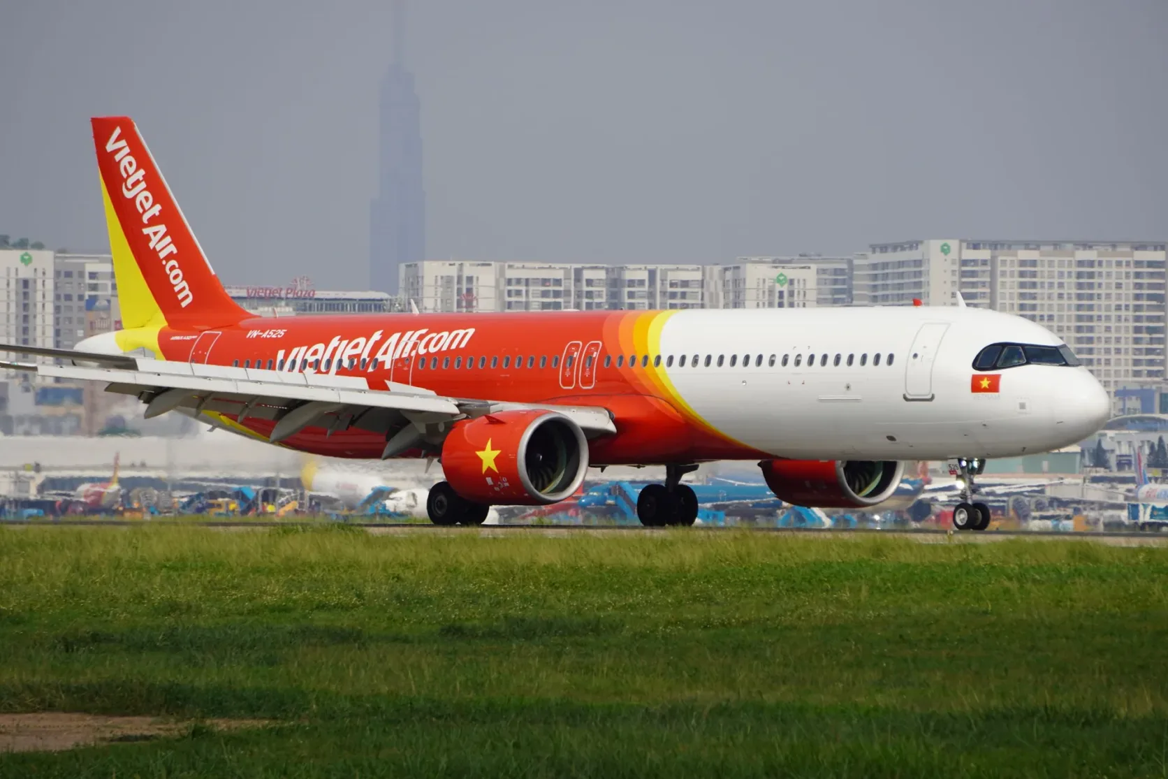 A jet on the ground at Tan Son Nhat with the Landmark 81 tower behind.